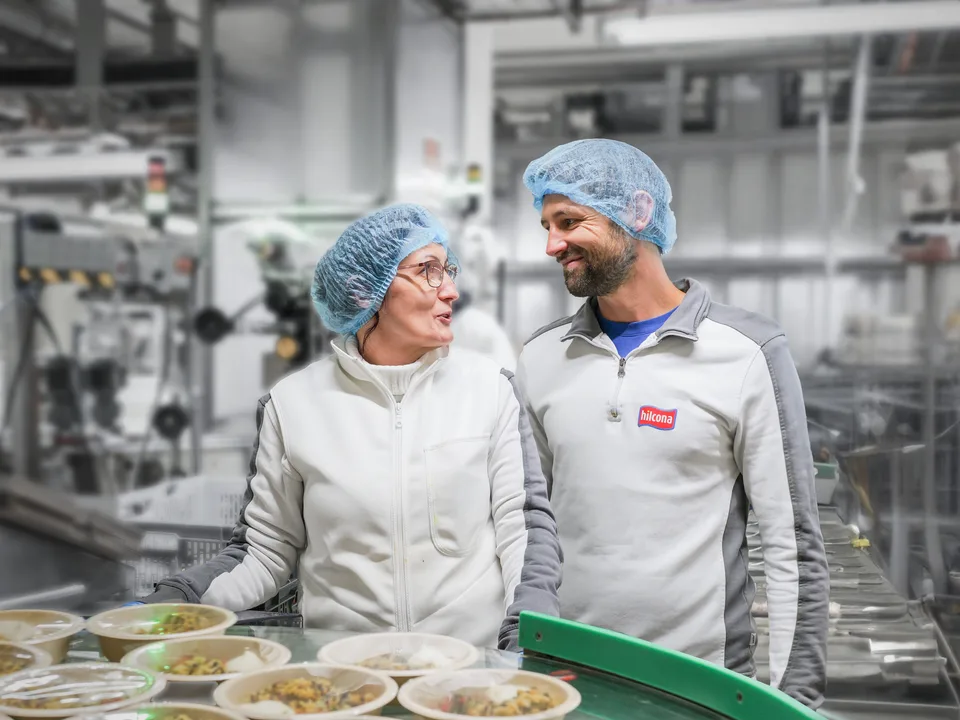 Zwei Hilcona-Mitarbeitende im Austausch an der Produktionslinie